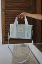 ZAZZA Blue cooler bag held by a hand against a wooden background