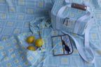 ZAZZA Blue Cooler Bag styled with picnic collection, a pair of sunglasses and lemons 