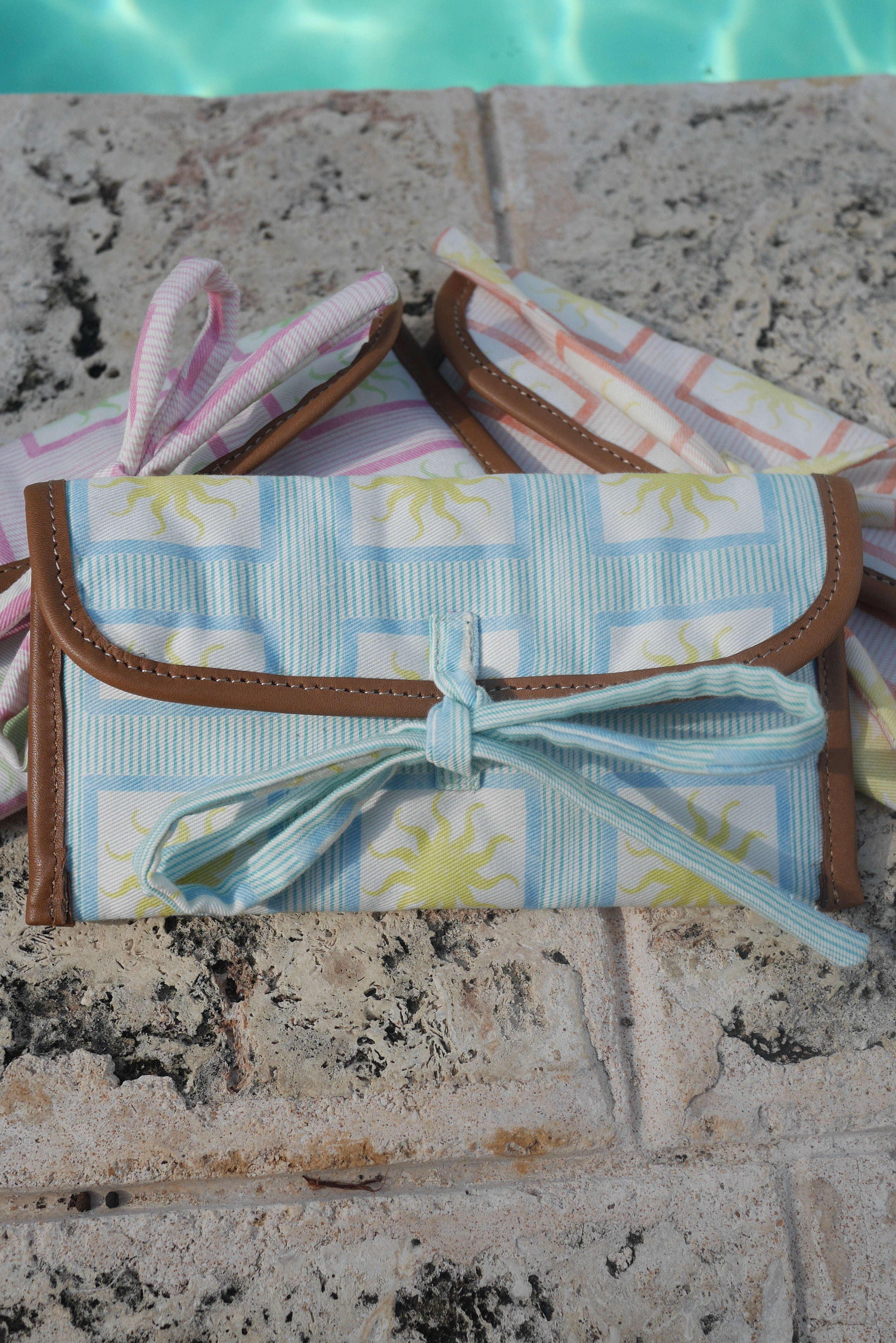 All ZAZZA sunglasses cases on a stone surface near a pool