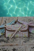 All ZAZZA sunglasses cases on a stone surface near a pool