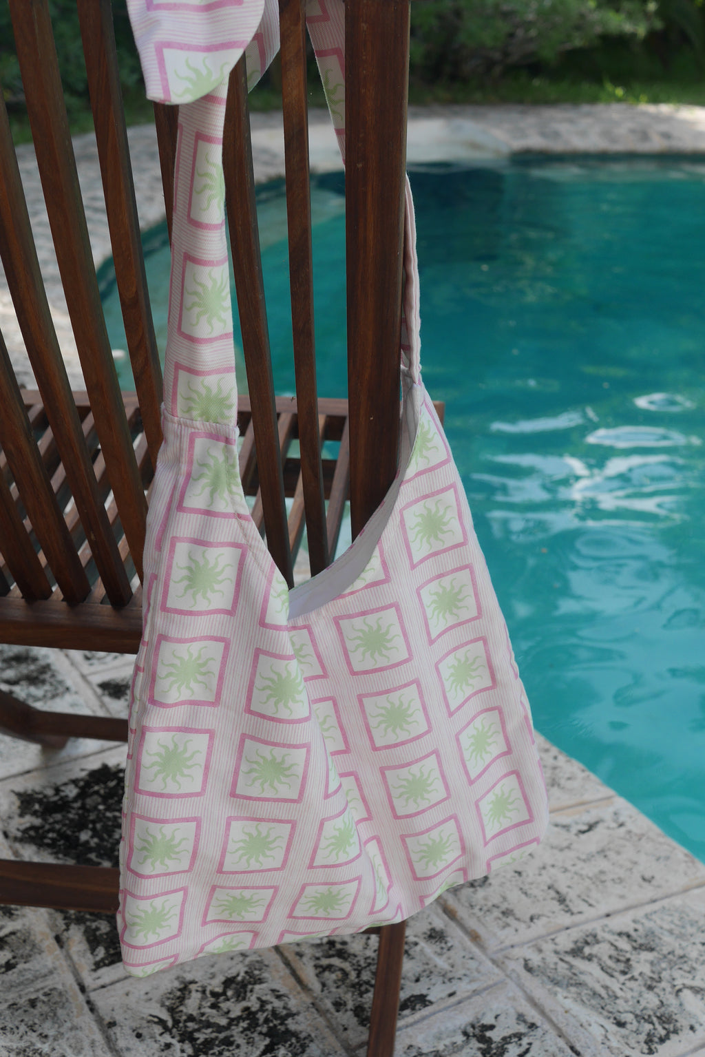 Pink ZAZZA Tote bag hanging on a chair by a pool