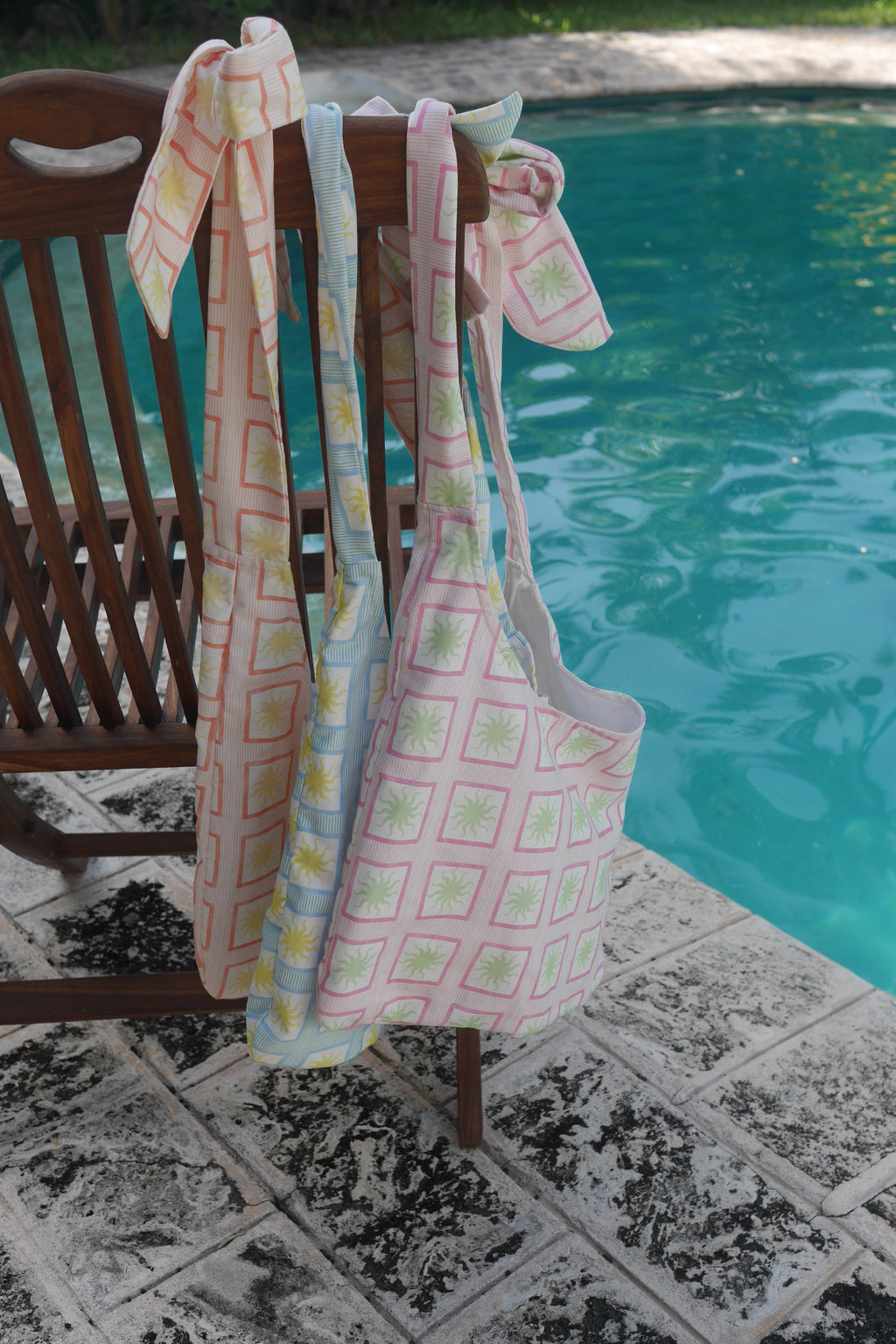 ZAZZA Tote bags hanging on a chair by a poolside