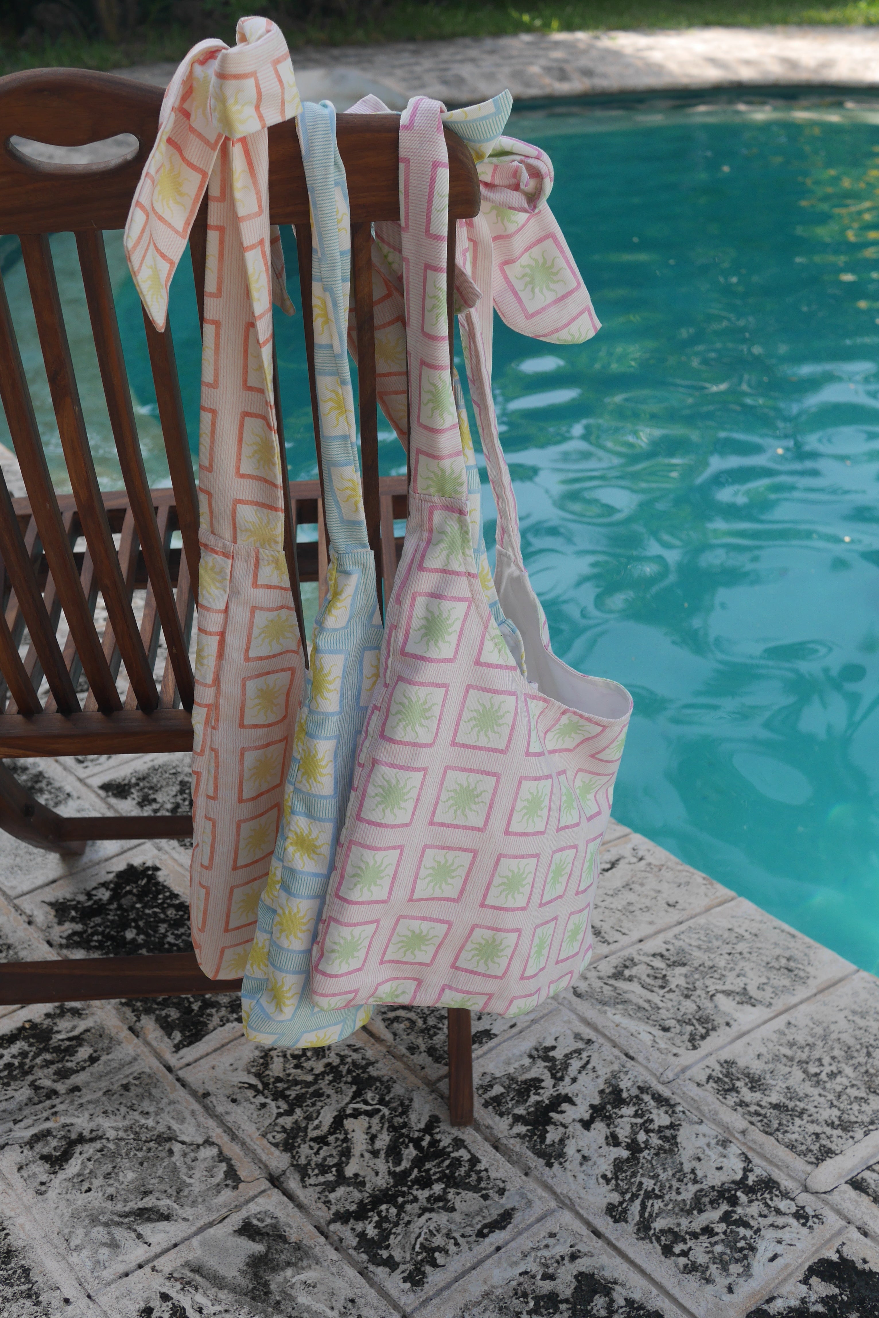ZAZZA Tote bags hanging on a chair by a poolside