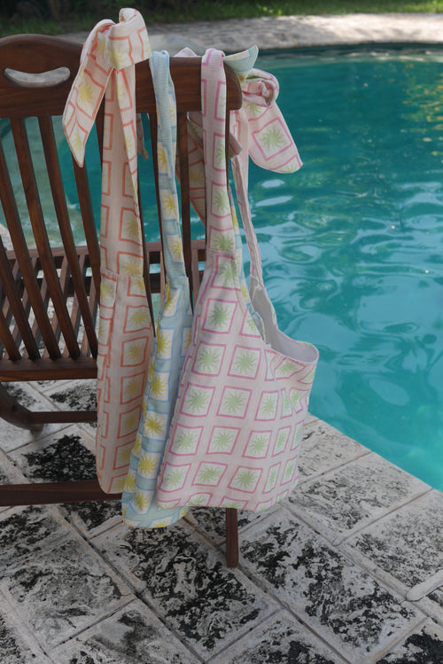 ZAZZA Tote bags hanging on a chair by a poolside