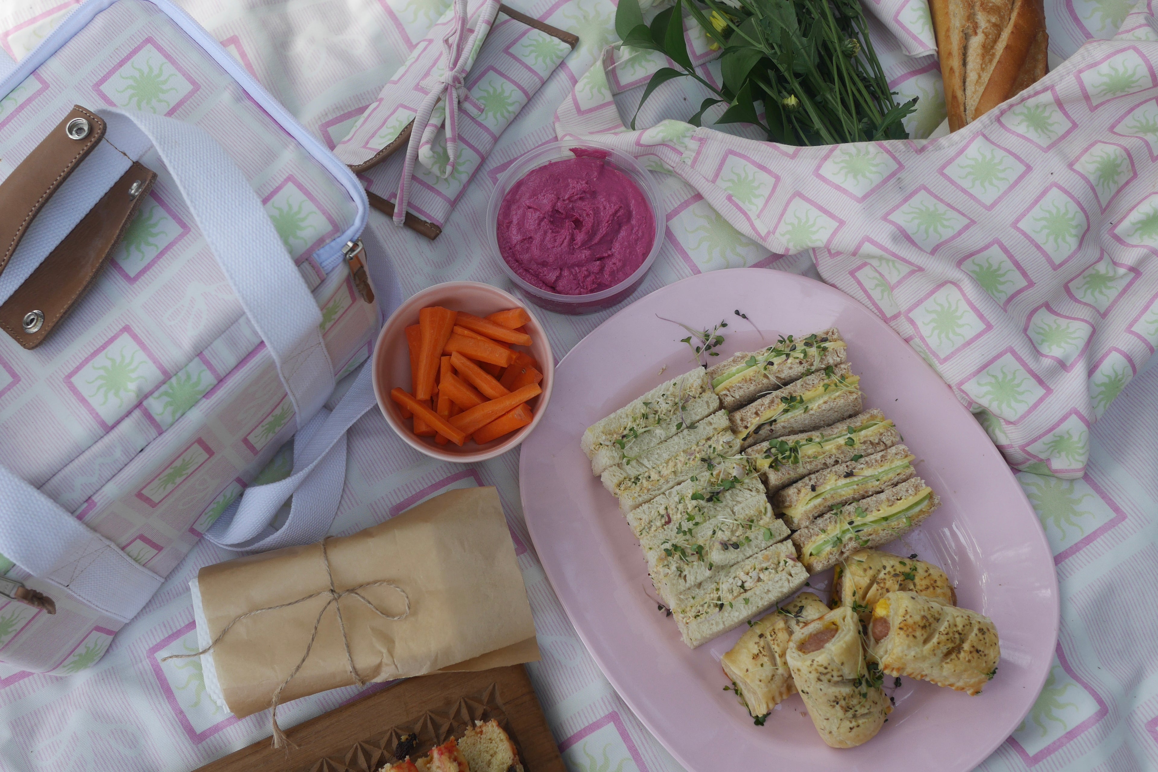 Picnic setup with sandwiches, carrots, bread etc. styled with the ZAZZA pink picnic collection 