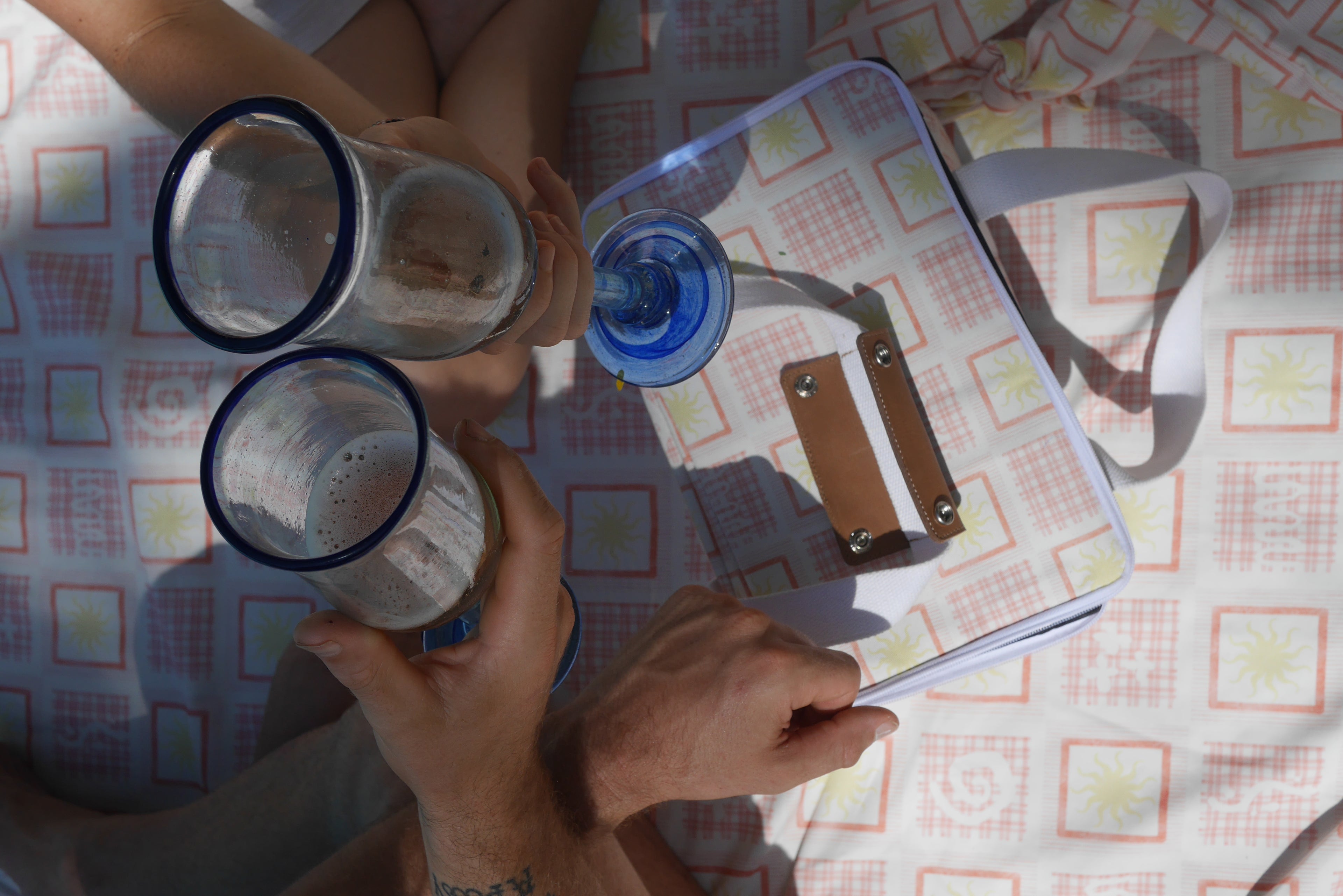Two people toasting  over the ZAZZA red picnic collection 